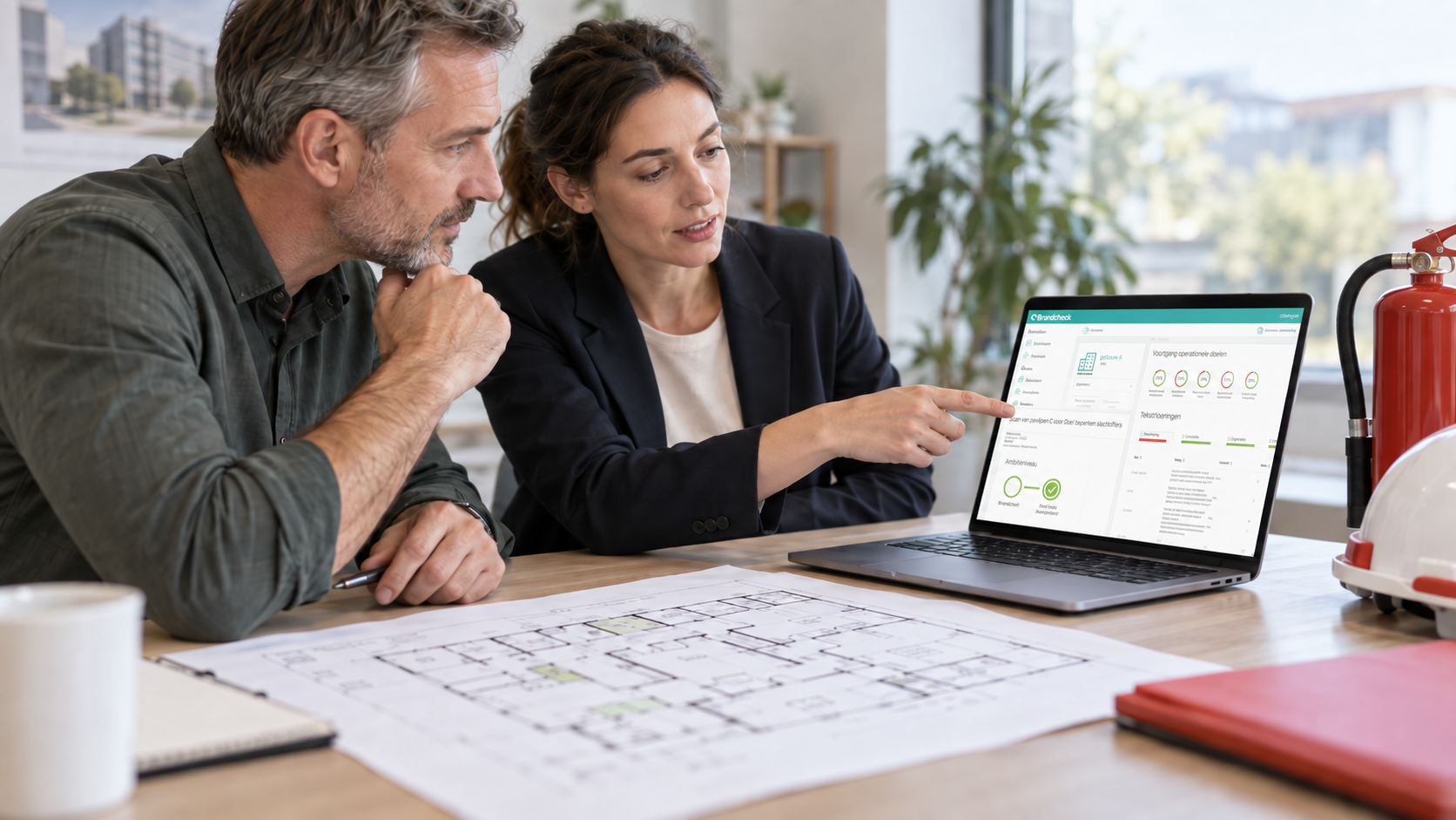 Beheerder en adviseur bekijken het Brandcheck-dashboard met de gebouwvoorraad op een laptop